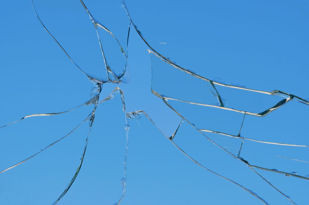 Shattered glass radiating cracks from a single impact point