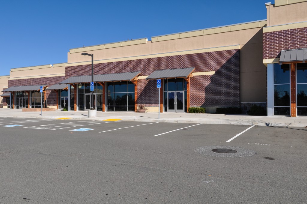 Retail strip with brick and stucco elevations and full height storefront entry doors