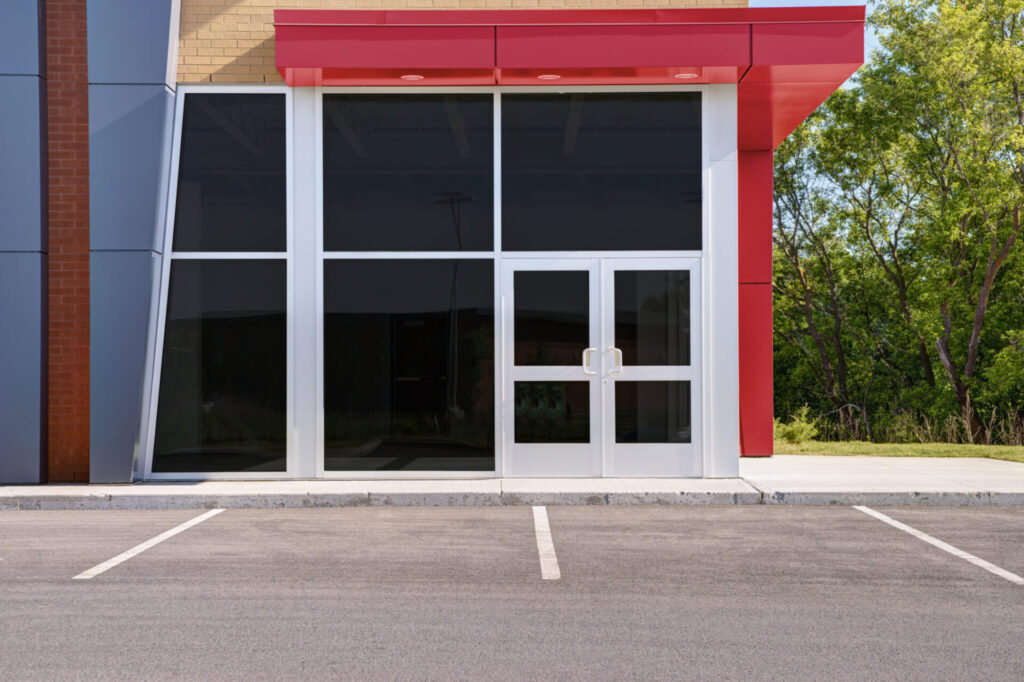 A commercial glass entrance door in a red storefront