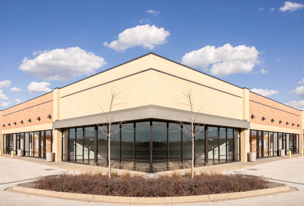 Single storey retail building with continuous storefront glazing along the corner elevation